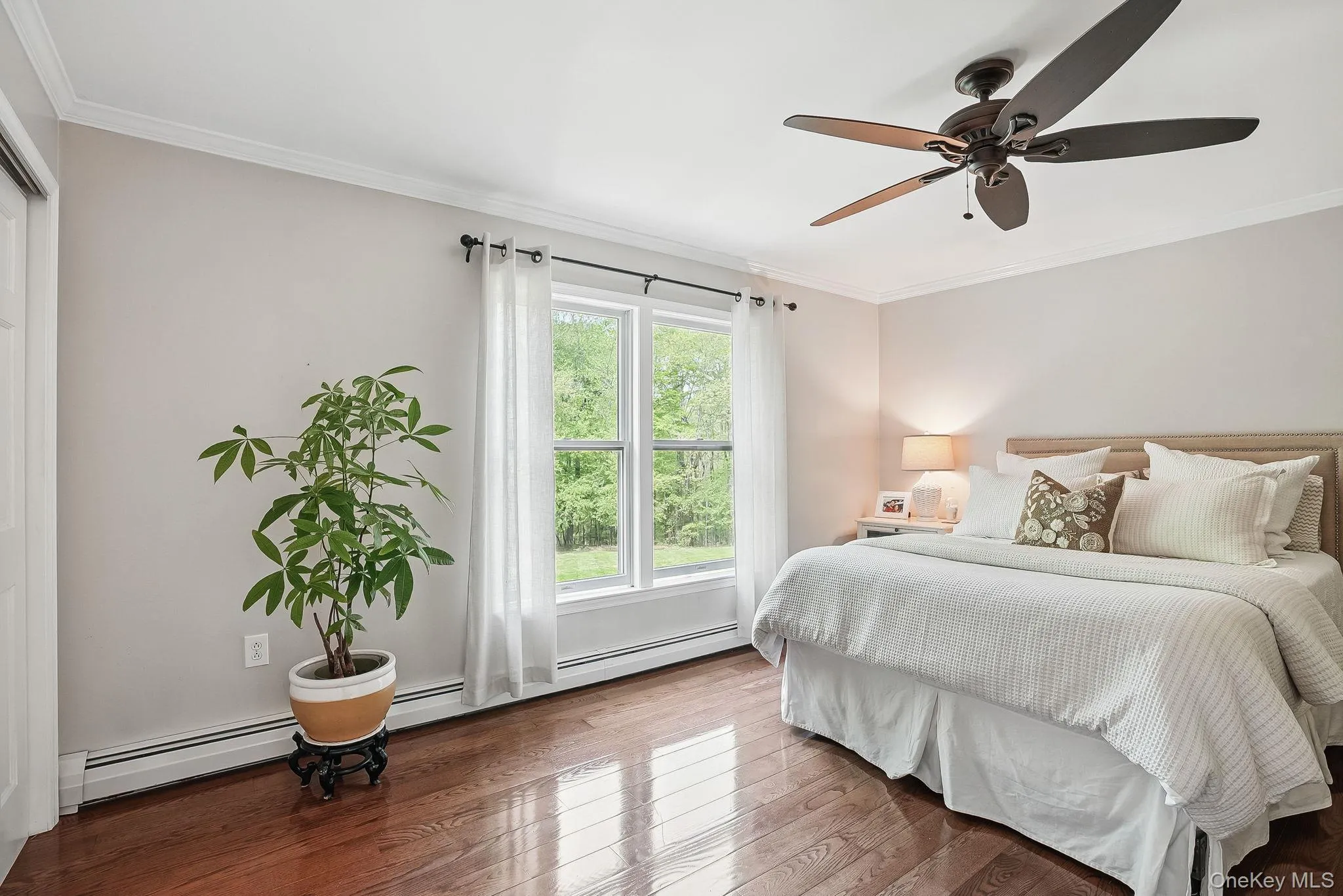 Bedroom featuring wood finished floors, crown molding, and ceiling fan Bedroom featuring wood finished floors, crown molding, and ceiling fan