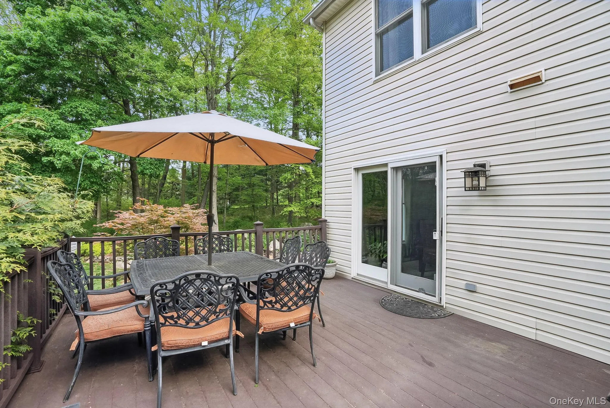 Wooden terrace featuring outdoor dining area and view of scattered trees Wooden terrace featuring outdoor dining area and view of scattered trees