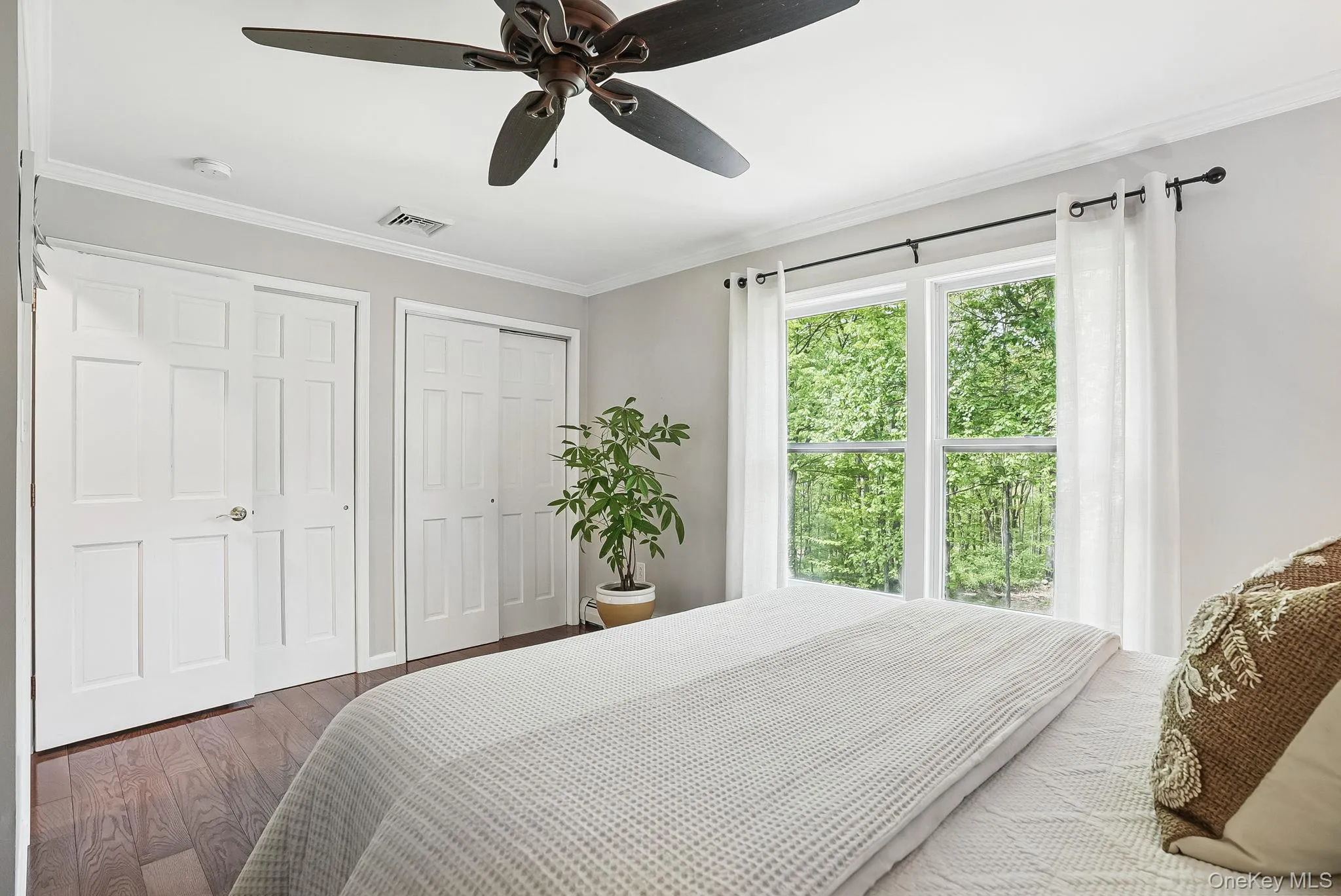 Bedroom featuring wood finished floors, ornamental molding, and ceiling fan Bedroom featuring wood finished floors, ornamental molding, and ceiling fan