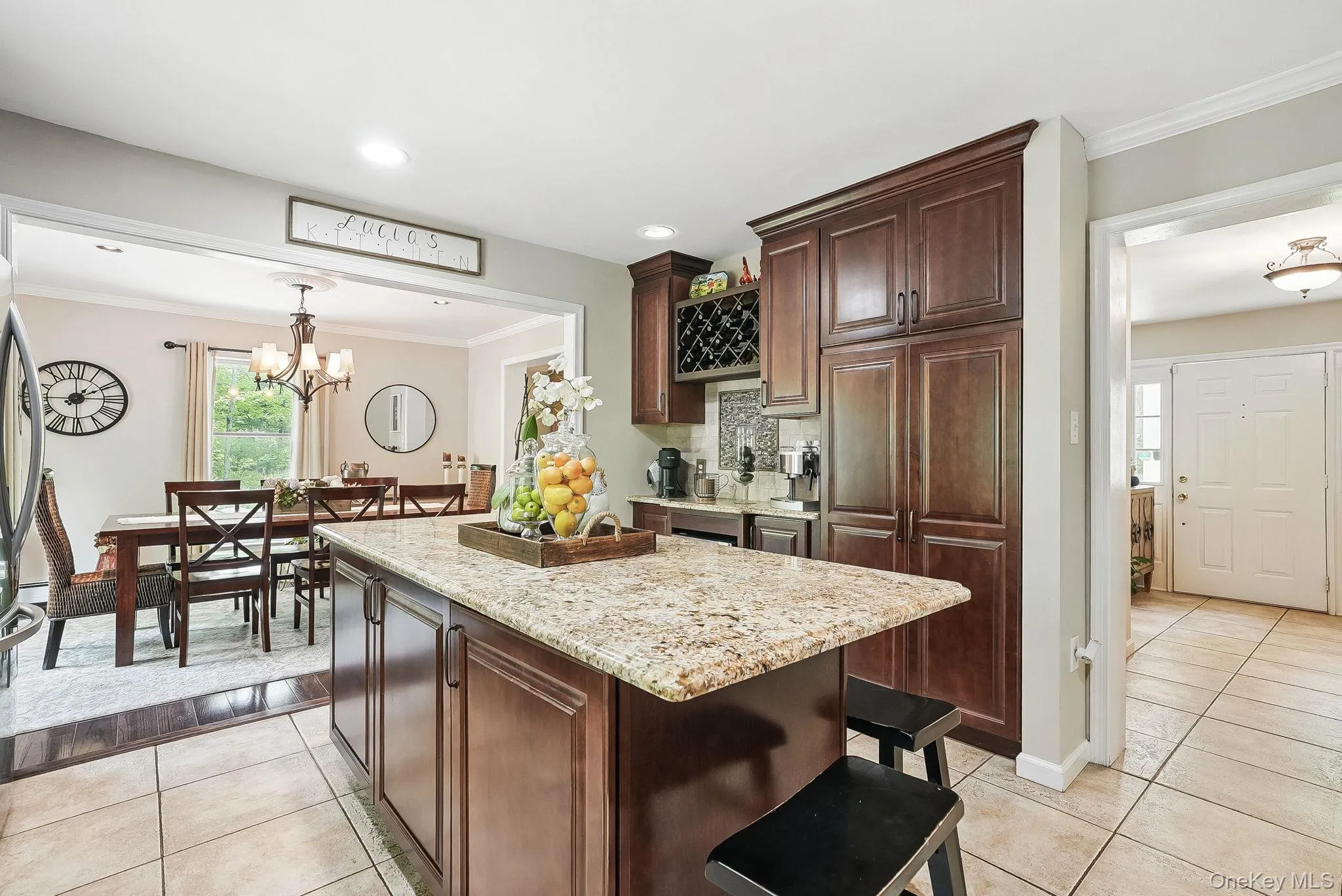 Kitchen with light tile patterned flooring, light stone countertops, ornamental molding, a center island, and recessed lighting Kitchen with light tile patterned flooring, light stone countertops, ornamental molding, a center island, and recessed lighting