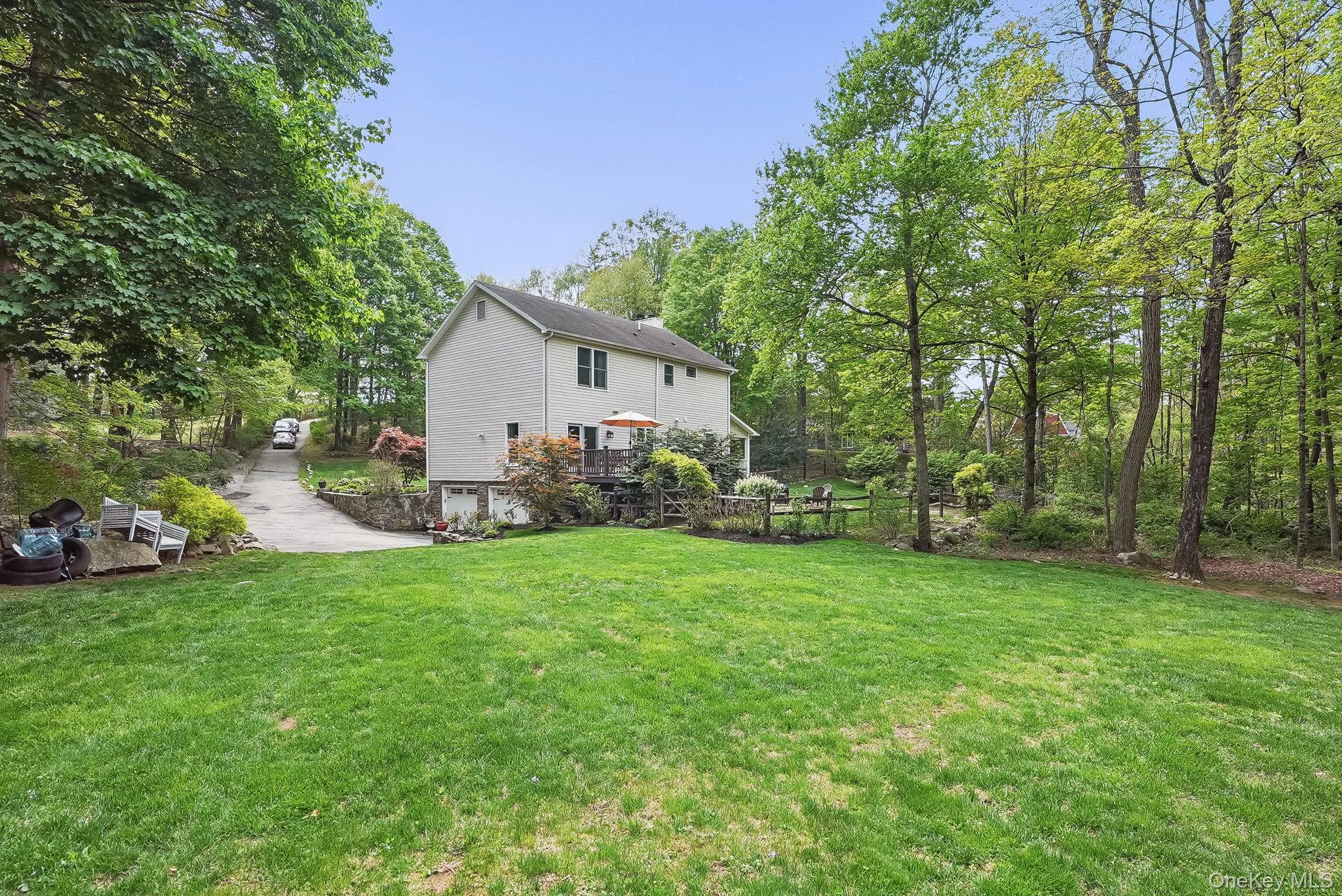 View of green lawn featuring a garage View of green lawn featuring a garage