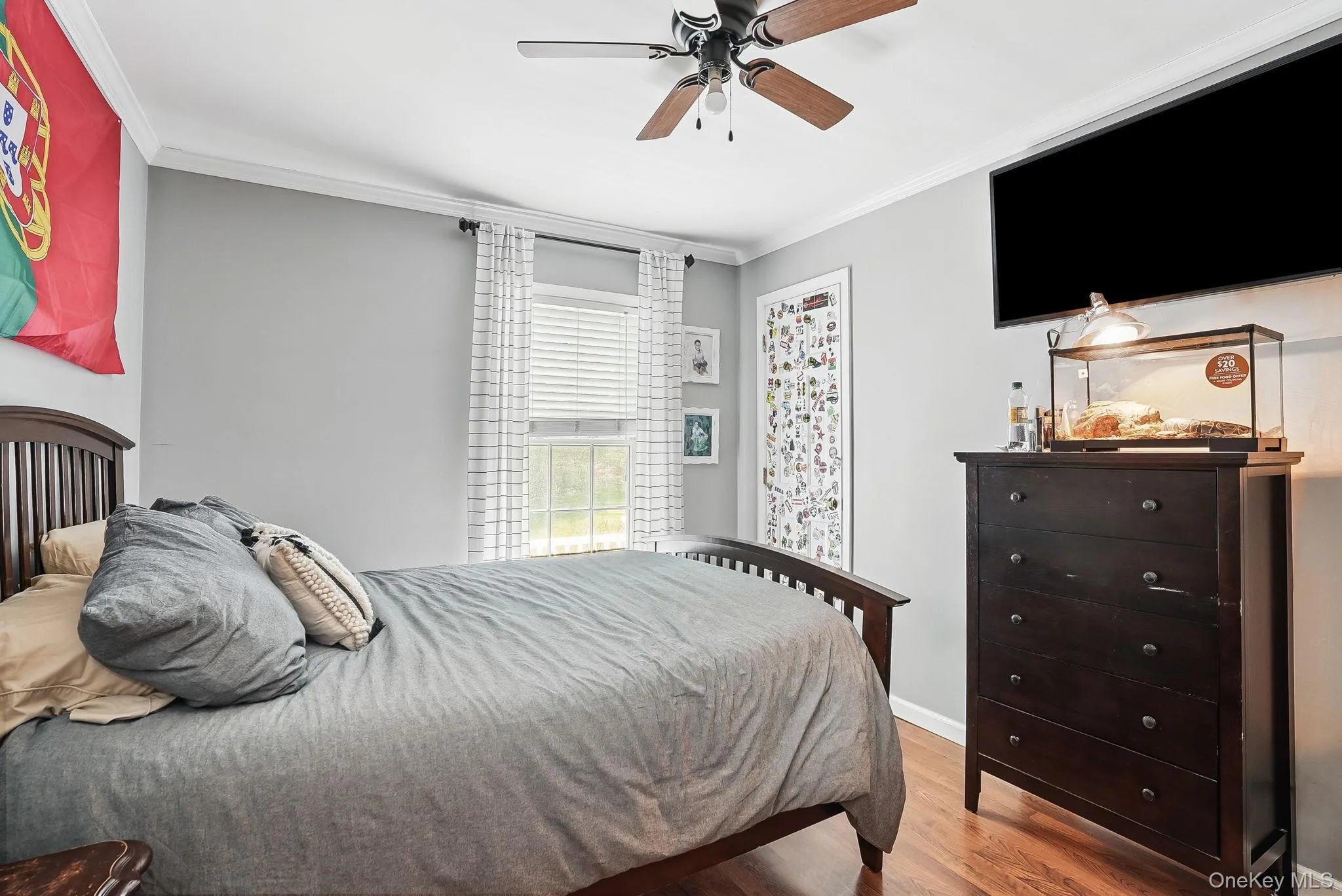 Bedroom with wood finished floors, ornamental molding, a ceiling fan, and baseboards Bedroom with wood finished floors, ornamental molding, a ceiling fan, and baseboards
