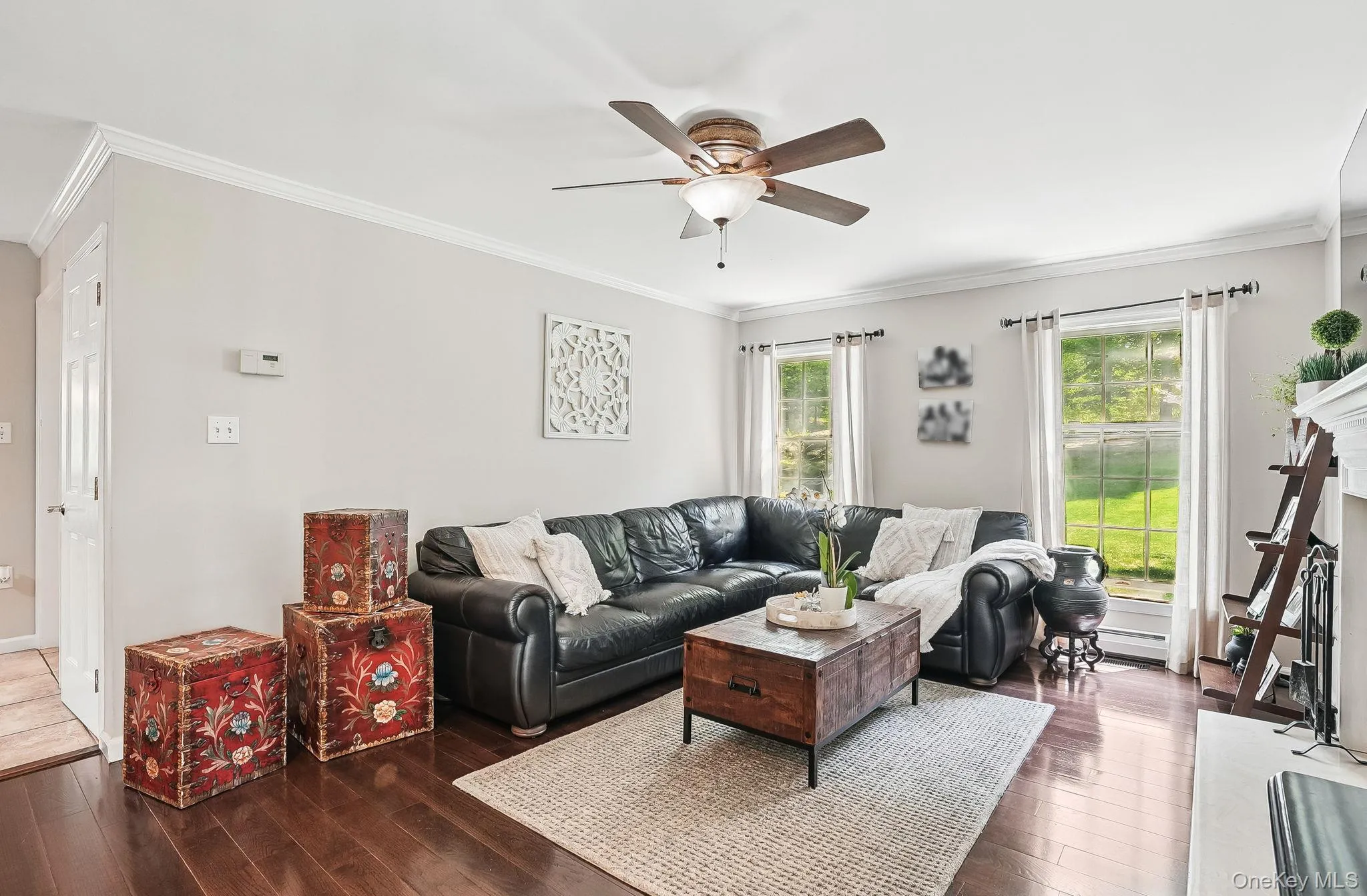 Living room with hardwood / wood-style flooring, healthy amount of natural light, a ceiling fan, and crown molding Living room with hardwood / wood-style flooring, healthy amount of natural light, a ceiling fan, and crown molding
