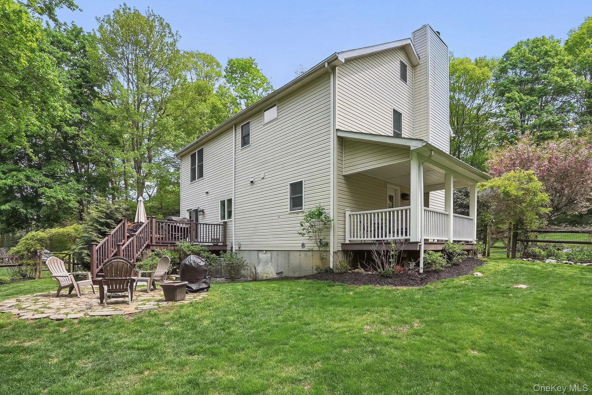 Rear view of property with a fire pit, a patio area, and a chimney Rear view of property with a fire pit, a patio area, and a chimney