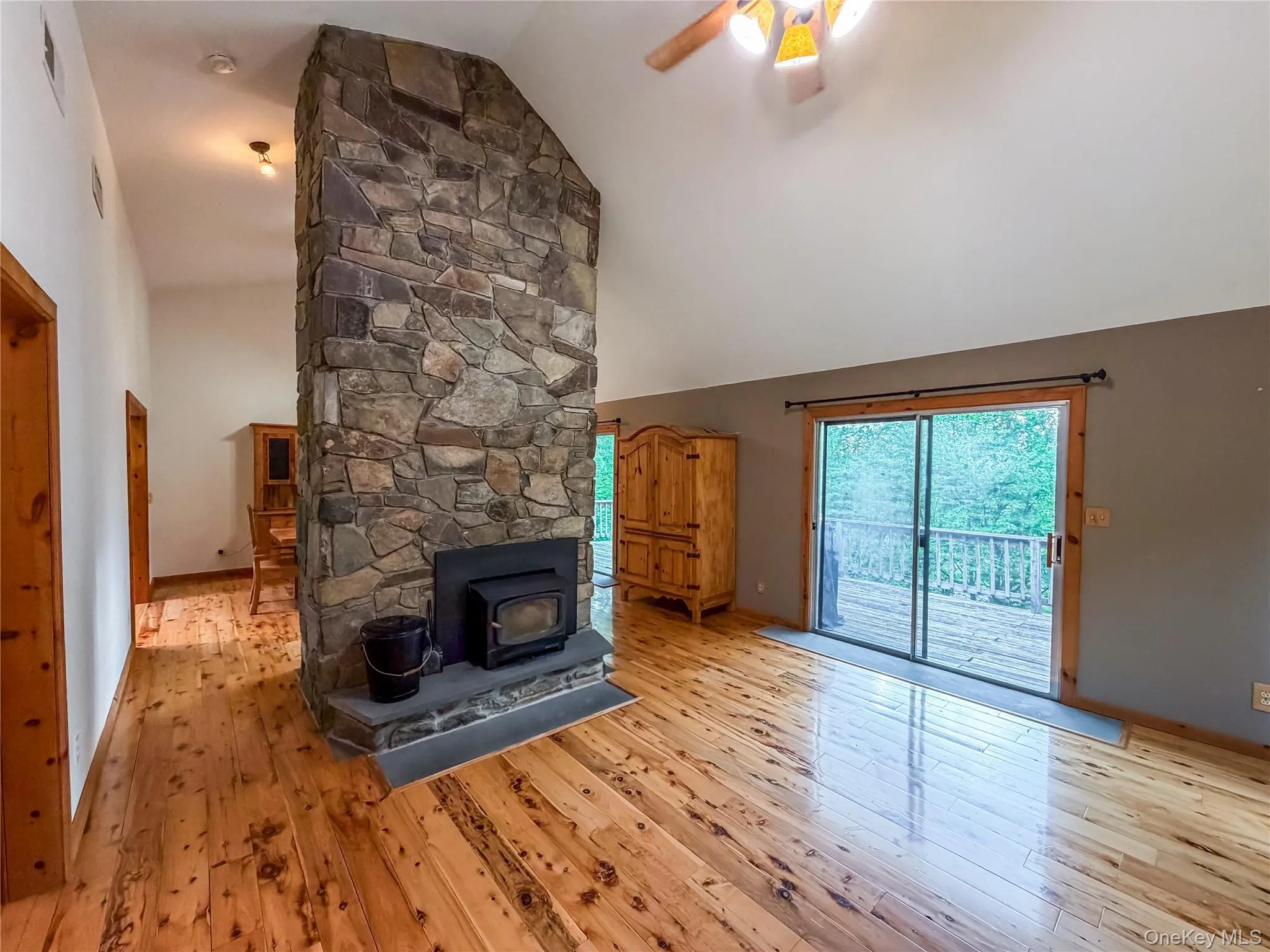 Double sided stone fireplace-Living room view, SGD to deck Double sided stone fireplace-Living room view, SGD to deck