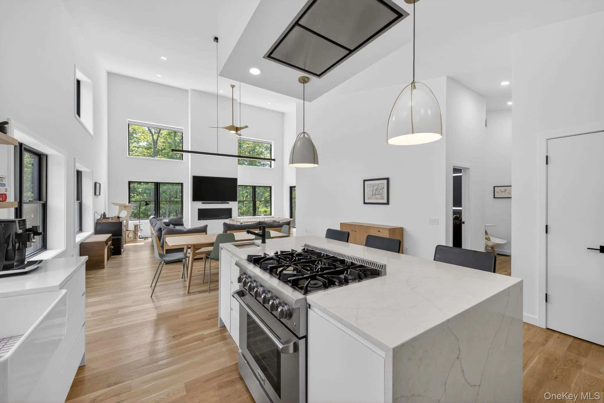 Modern kitchen featuring a gas range on a waterfall countertop island with seating Modern kitchen featuring a gas range on a waterfall countertop island with seating