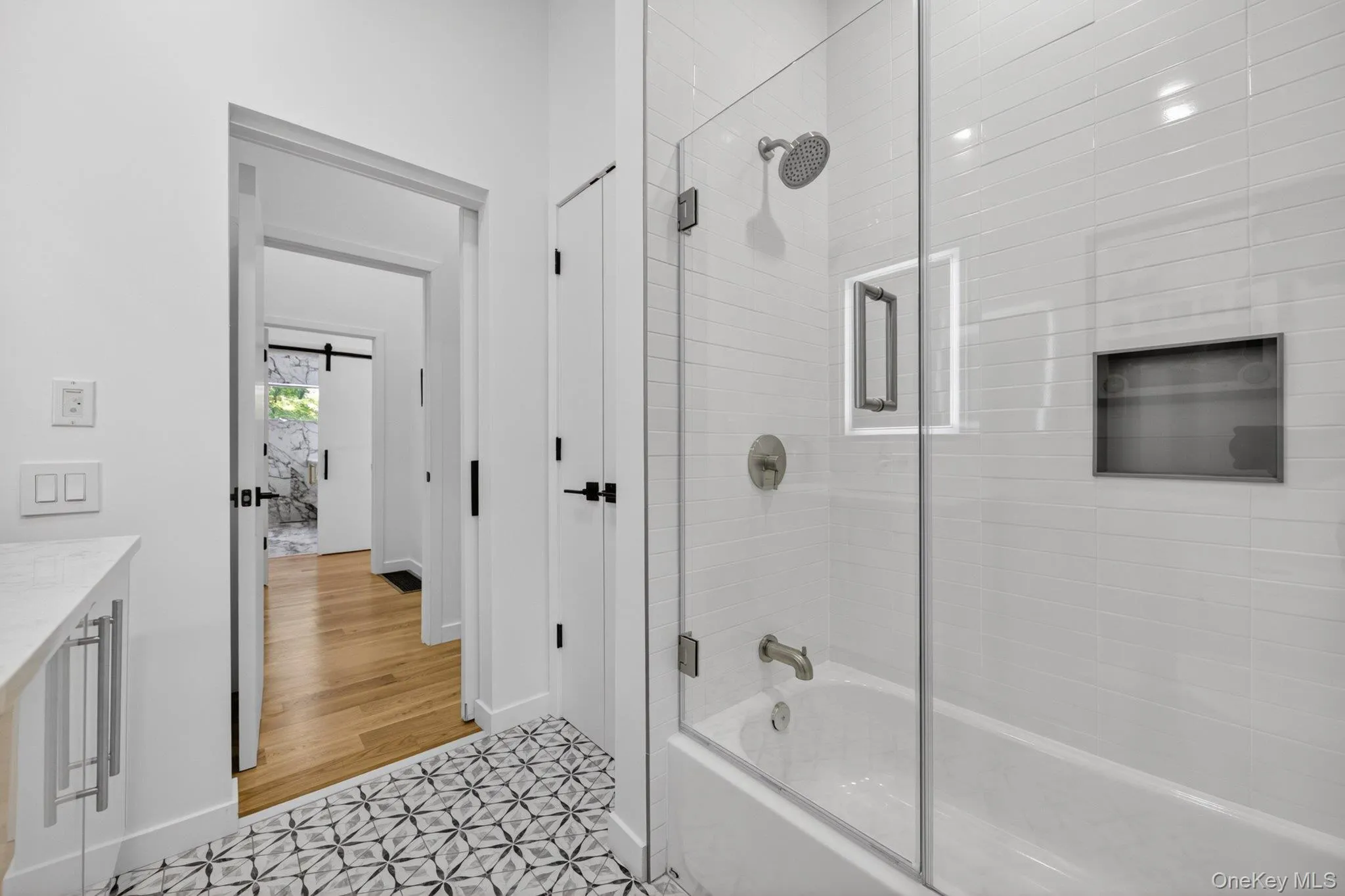 Bathroom featuring a glass-enclosed shower-tub combination Bathroom featuring a glass-enclosed shower-tub combination