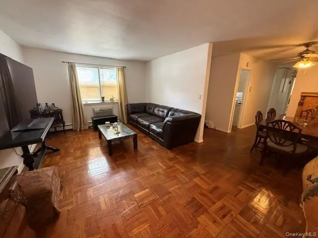 Parquet wood-finish flooring throughout, light-colored wall paint, a window with blinds and the dining area to the right. Parquet wood-finish flooring throughout, light-colored wall paint, a window with blinds and the dining area to the right.