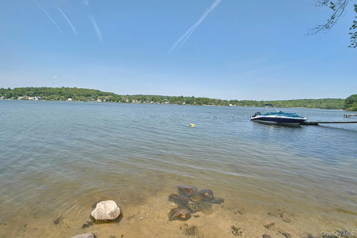 Lakefront property featuring a private boat dock and sandy shore access Lakefront property featuring a private boat dock and sandy shore access