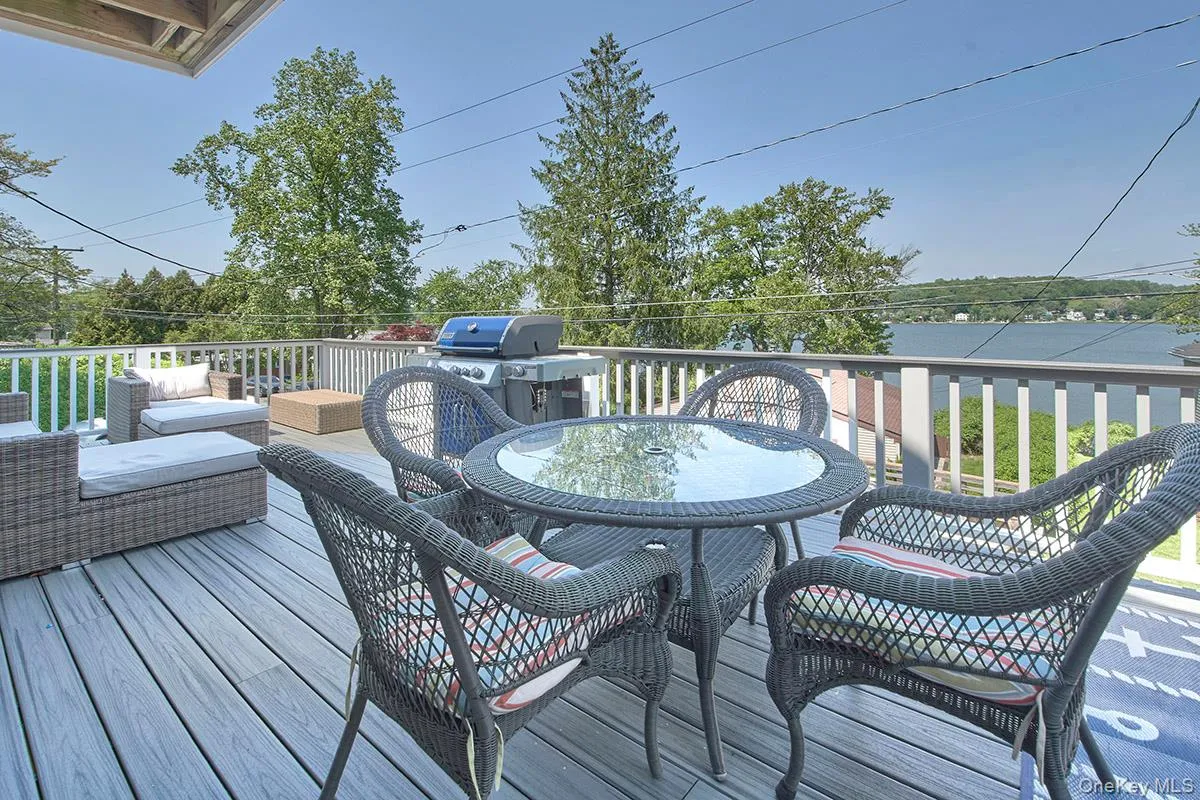 Spacious outdoor deck with composite decking and white railing, offering water scenery Spacious outdoor deck with composite decking and white railing, offering water scenery
