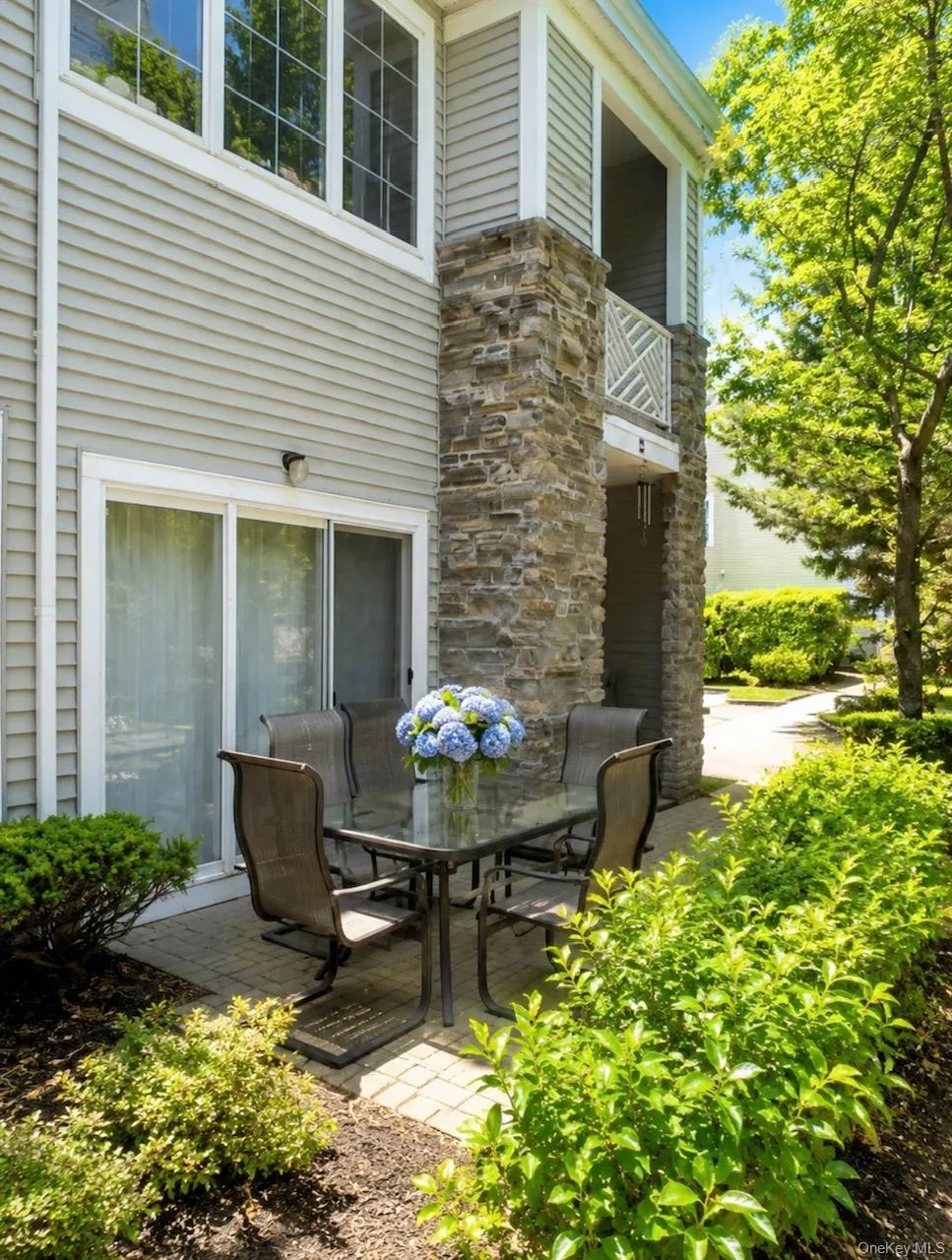 Private paver patio with landscaping, stone veneer column, and sliding glass door access Private paver patio with landscaping, stone veneer column, and sliding glass door access