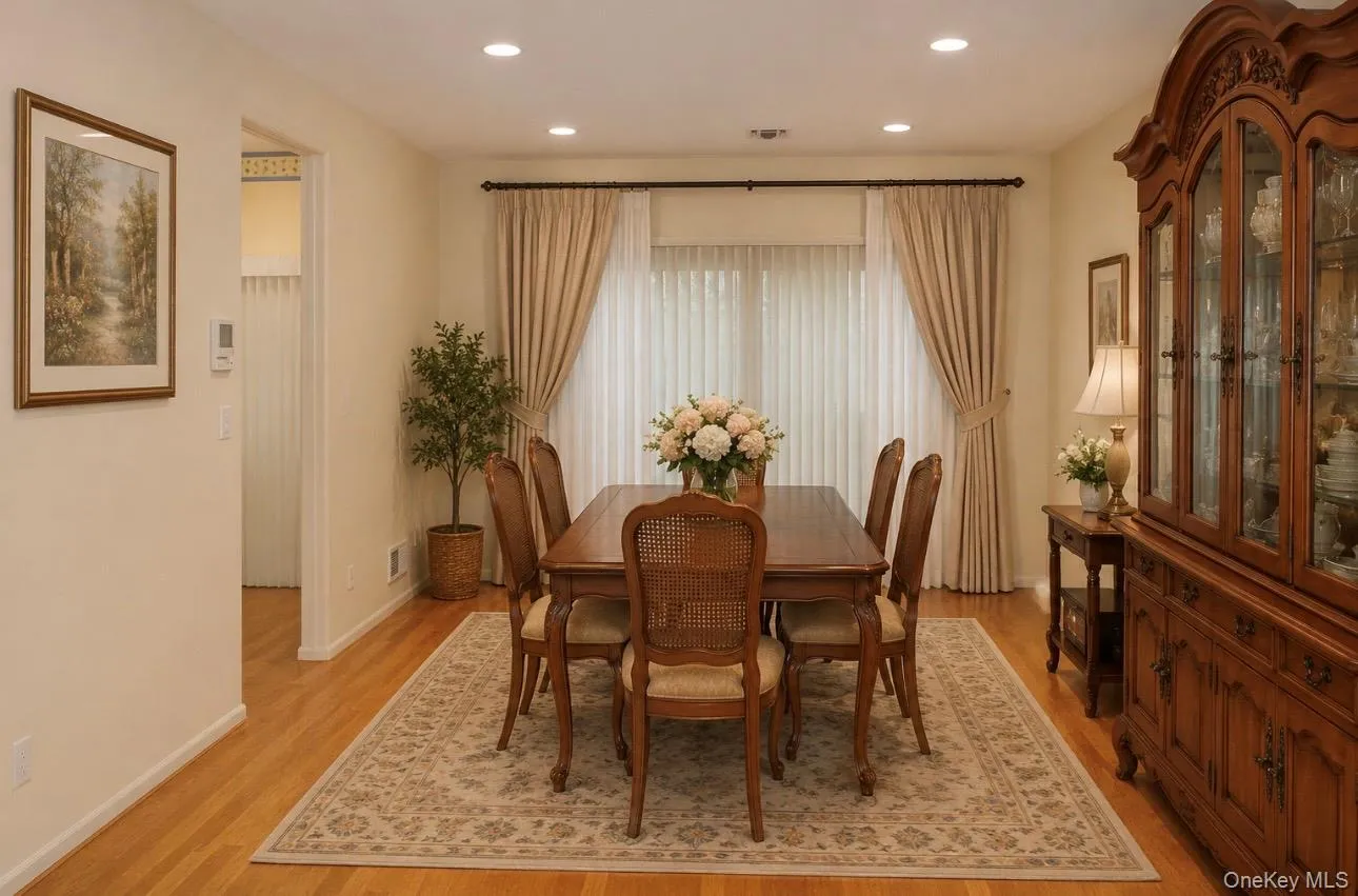 Open Dining Room area featuring wood-finish flooring, recessed lighting, and sliders with vertical blinds Open Dining Room area featuring wood-finish flooring, recessed lighting, and sliders with vertical blinds