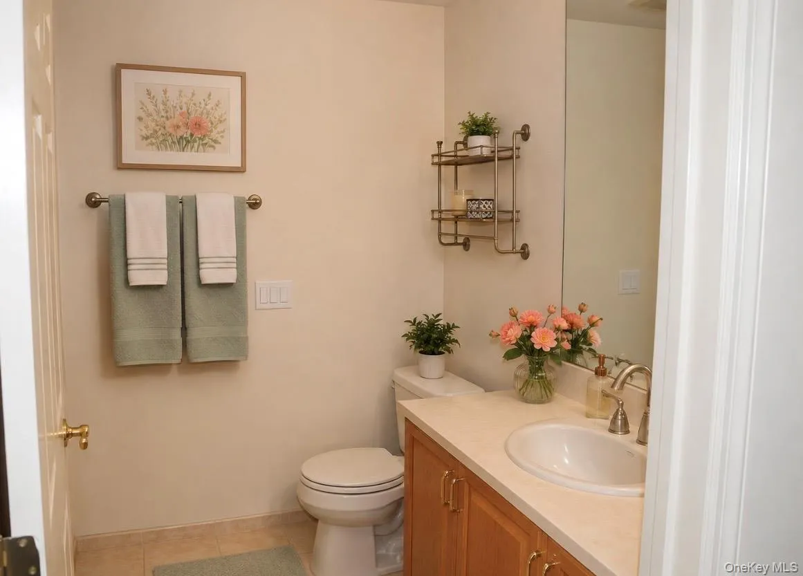 Bathroom featuring vanity with a solid surface countertop, an undermount sink, and wood-finish cabinetry and shower Bathroom featuring vanity with a solid surface countertop, an undermount sink, and wood-finish cabinetry and shower