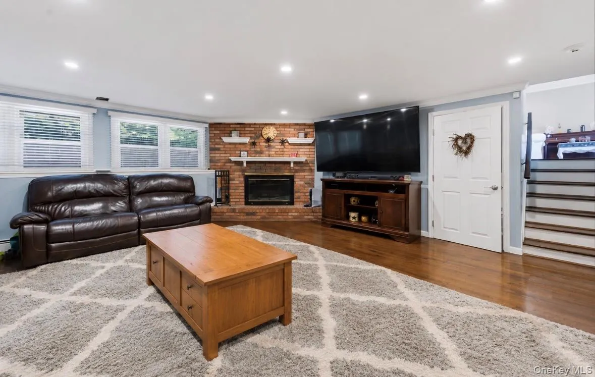Lower level living area with a brick-surround fireplace and built-in mantle Lower level living area with a brick-surround fireplace and built-in mantle