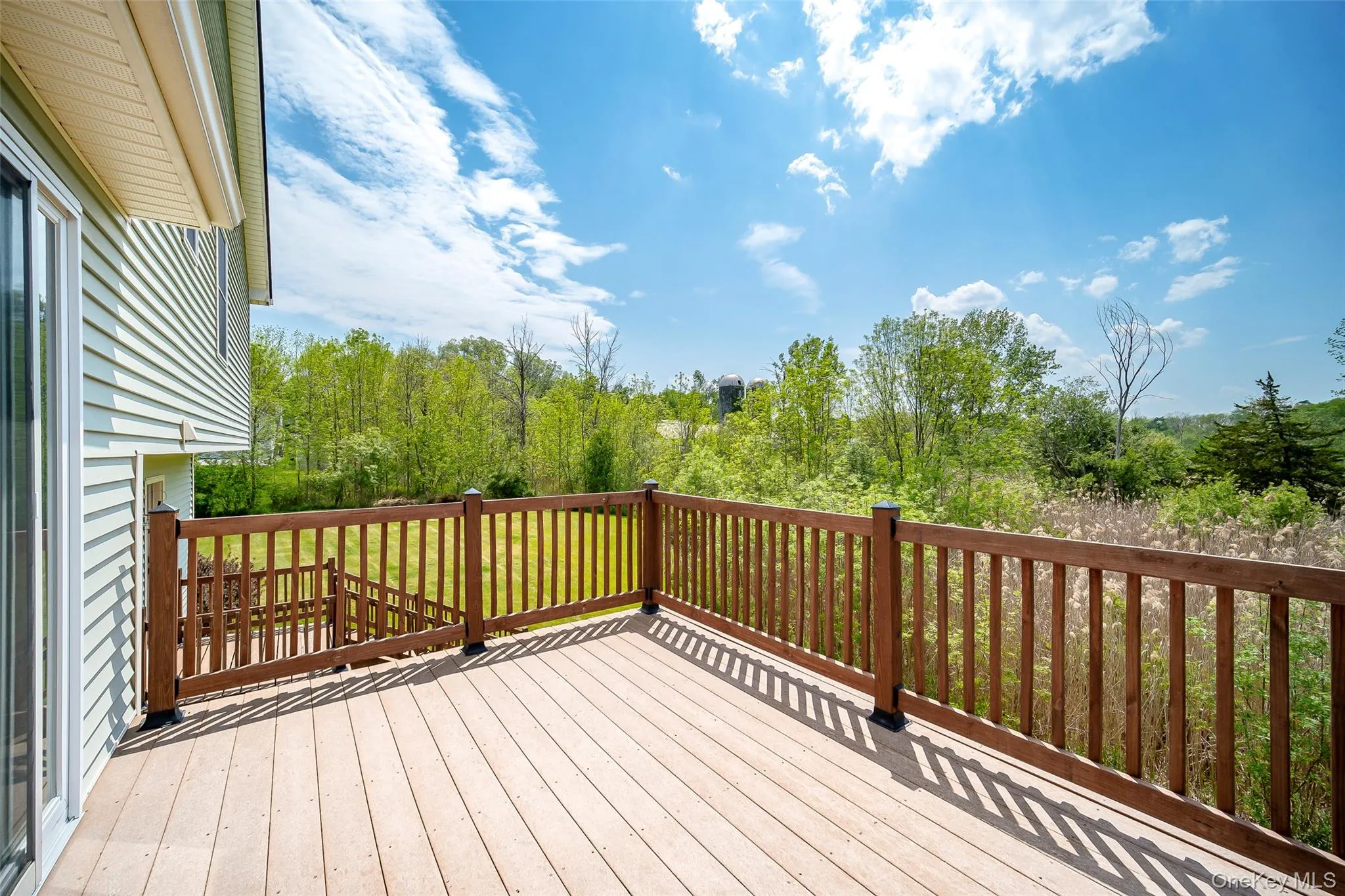 Spacious outdoor deck featuring light-toned decking and dark wood railings Spacious outdoor deck featuring light-toned decking and dark wood railings