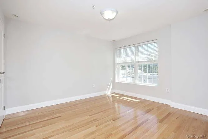 Unfurnished room with light wood-style flooring and baseboards Unfurnished room with light wood-style flooring and baseboards