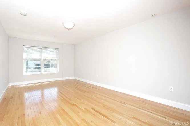Spare room with light wood-style flooring and baseboards Spare room with light wood-style flooring and baseboards
