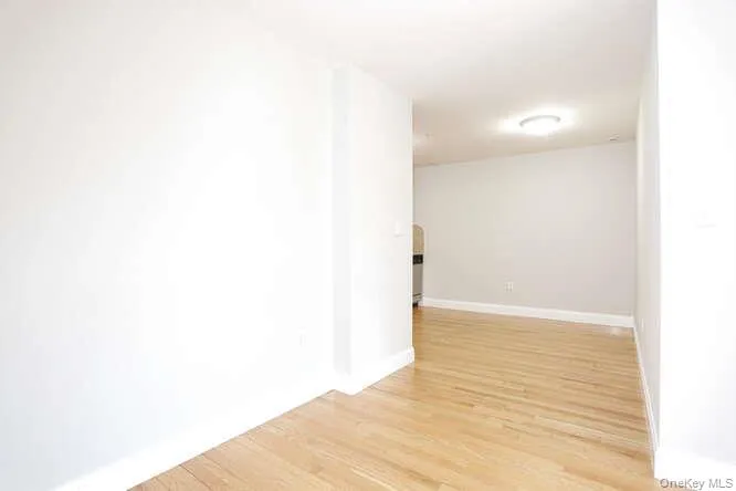 Spare room featuring light wood-style floors and baseboards Spare room featuring light wood-style floors and baseboards