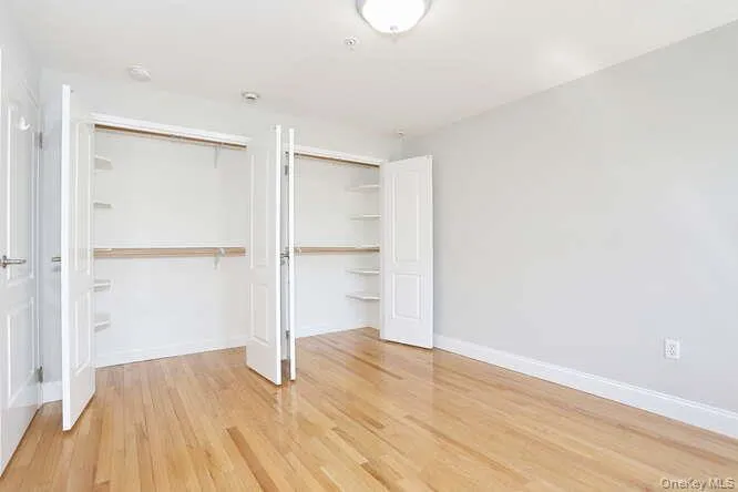 Unfurnished bedroom with wood finished floors, a closet, and baseboards Unfurnished bedroom with wood finished floors, a closet, and baseboards