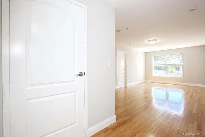 Empty room with light wood-type flooring and baseboards Empty room with light wood-type flooring and baseboards