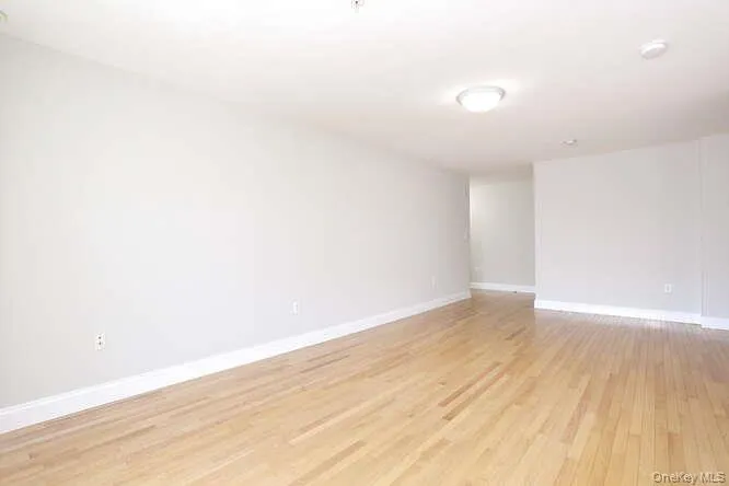 Empty room with light wood-style floors and baseboards Empty room with light wood-style floors and baseboards