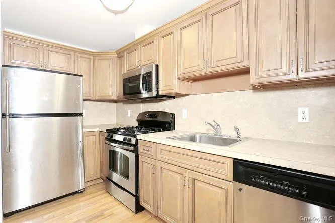 Kitchen featuring appliances with stainless steel finishes, a sink, light countertops, and tasteful backsplash Kitchen featuring appliances with stainless steel finishes, a sink, light countertops, and tasteful backsplash