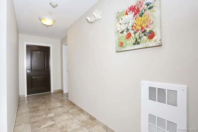 Hallway featuring heating unit and baseboards Hallway featuring heating unit and baseboards