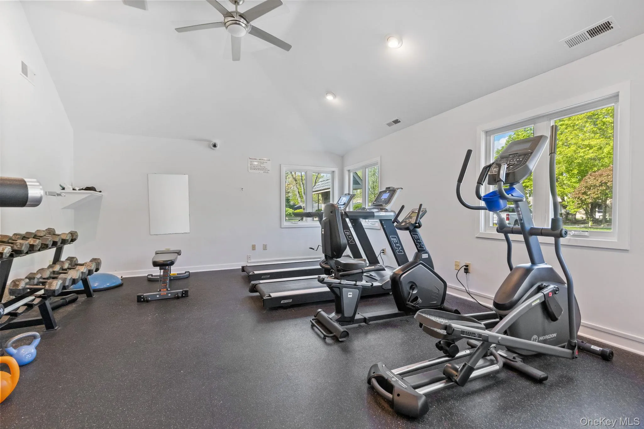 Gym with ceiling fan, baseboards, and high vaulted ceiling Gym with ceiling fan, baseboards, and high vaulted ceiling
