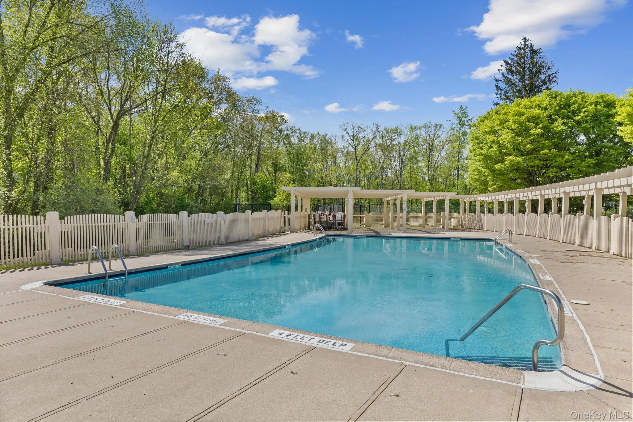 Community pool with fence and a patio Community pool with fence and a patio