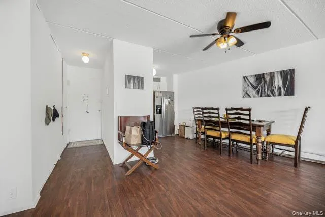 Open concept living space featuring wood-finish flooring throughout, a ceiling fan with integrated lighting, and white walls Open concept living space featuring wood-finish flooring throughout, a ceiling fan with integrated lighting, and white walls