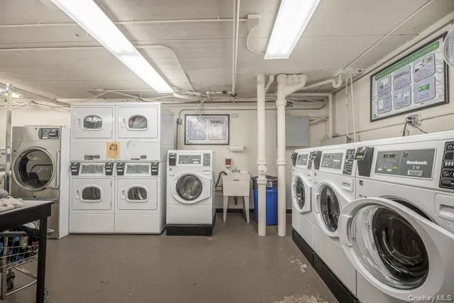 On-site laundry facility featuring multiple front-loading washers and dryers, utility sink, and overhead fluorescent lighting On-site laundry facility featuring multiple front-loading washers and dryers, utility sink, and overhead fluorescent lighting