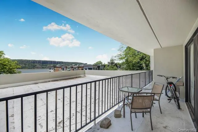 Covered balcony featuring a water backdrop and distant treeline Covered balcony featuring a water backdrop and distant treeline