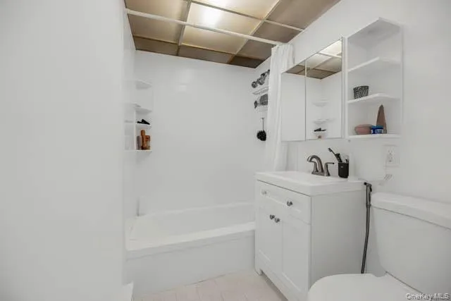 Bathroom featuring a white vanity with integrated sink, chrome faucet, and a wall-mounted mirrored cabinet Bathroom featuring a white vanity with integrated sink, chrome faucet, and a wall-mounted mirrored cabinet