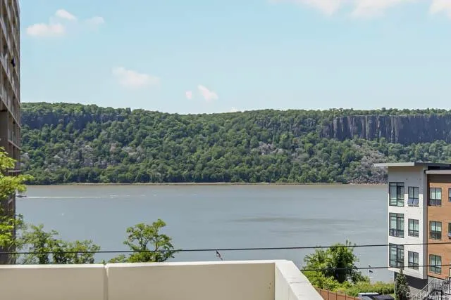 Waterfront panorama featuring a distant wooded cliff face and open water Waterfront panorama featuring a distant wooded cliff face and open water