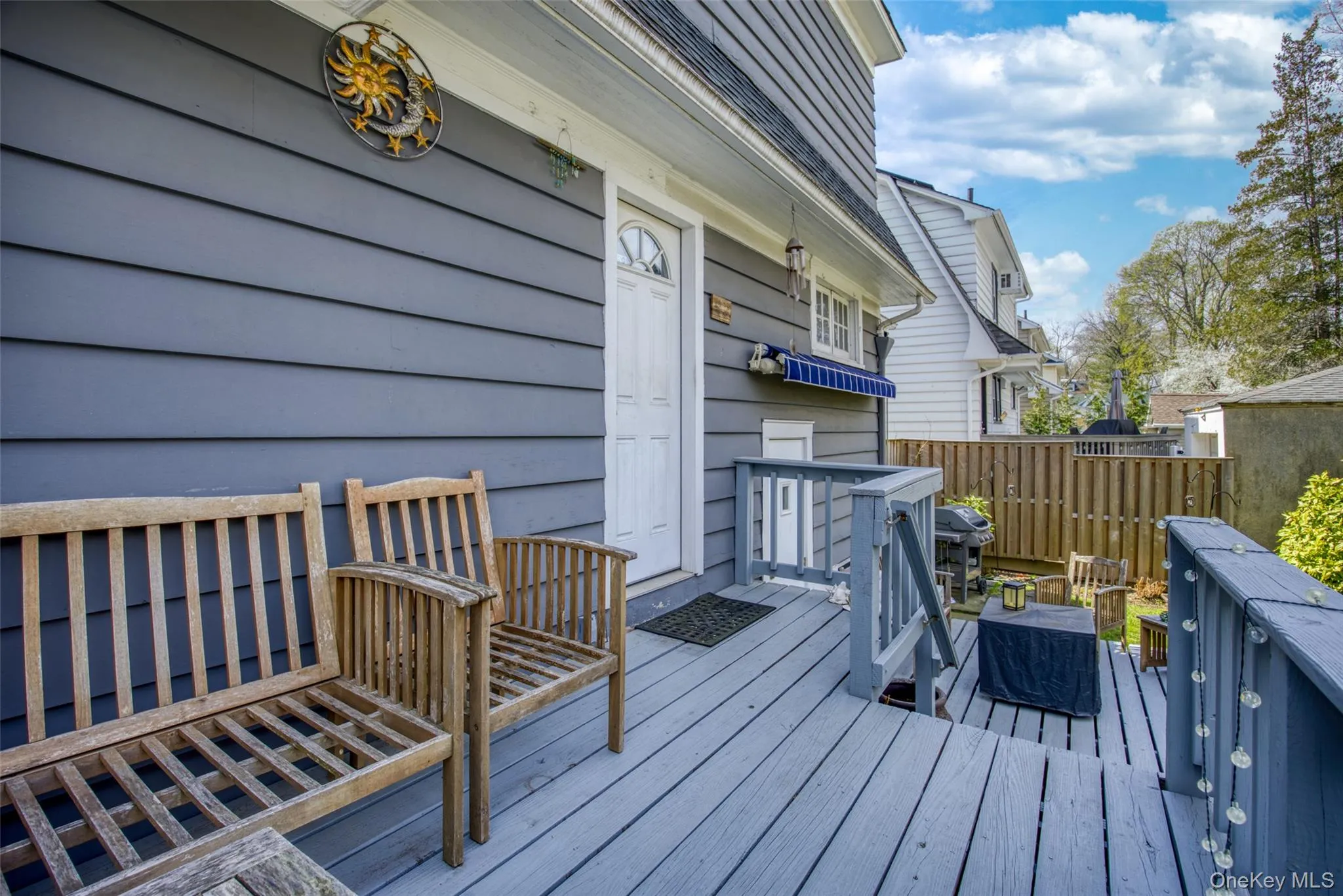 Exterior deck featuring painted wood flooring, painted wood railings, and a privacy fence Exterior deck featuring painted wood flooring, painted wood railings, and a privacy fence