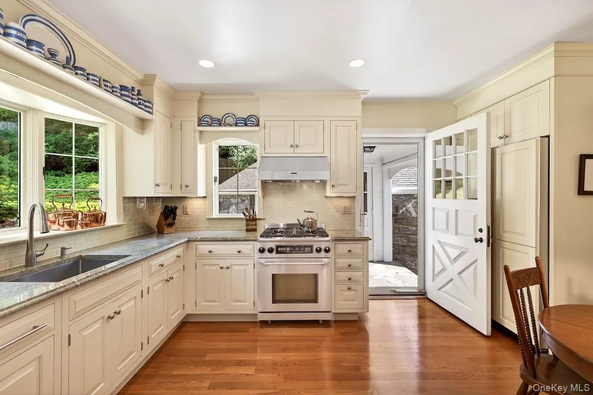 Eat-in kitchen with hardwood floors and door to breezeway and patio Eat-in kitchen with hardwood floors and door to breezeway and patio