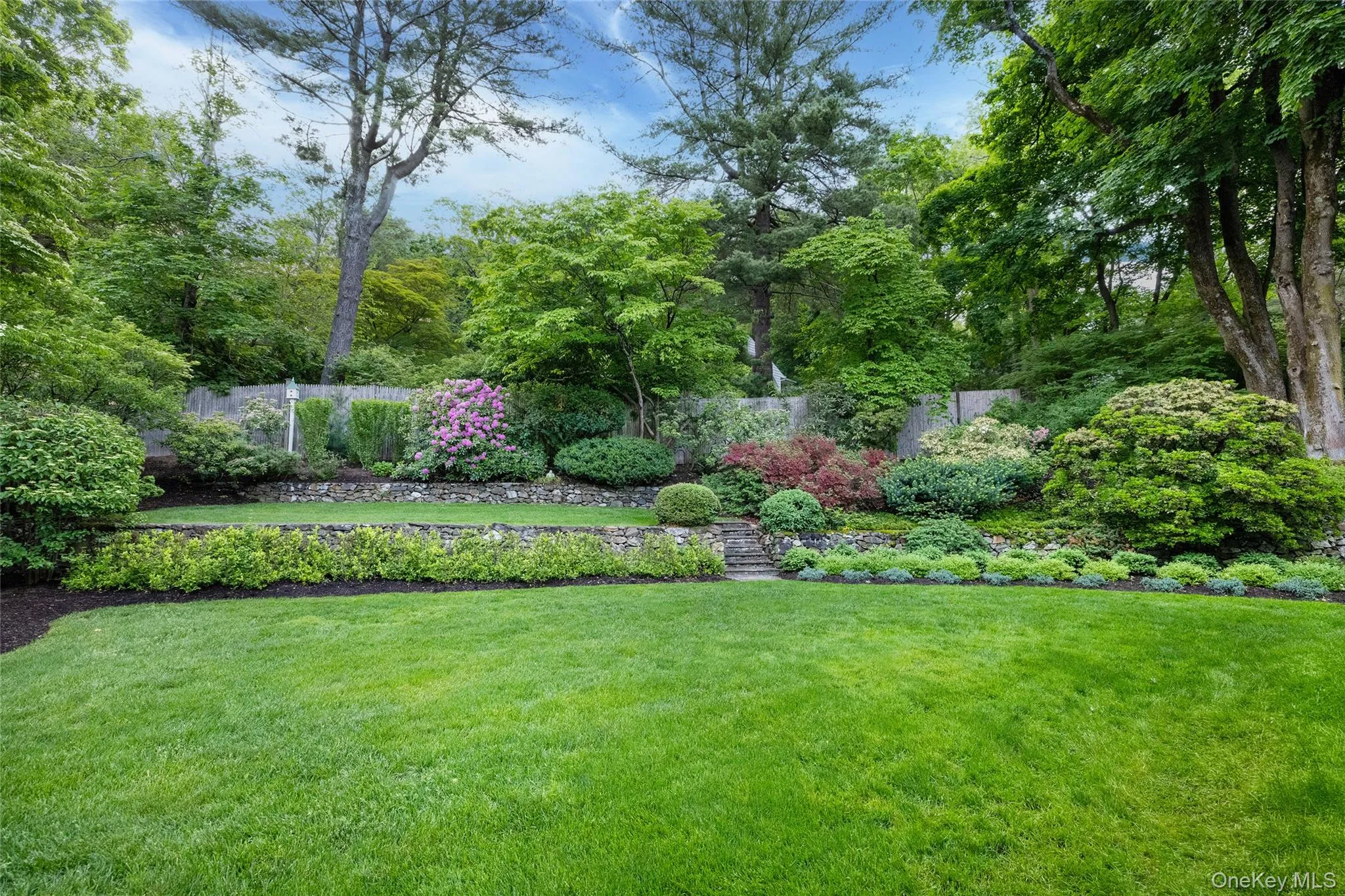 Exquisite grounds feature tiered planting areas with stone retaining walls Exquisite grounds feature tiered planting areas with stone retaining walls