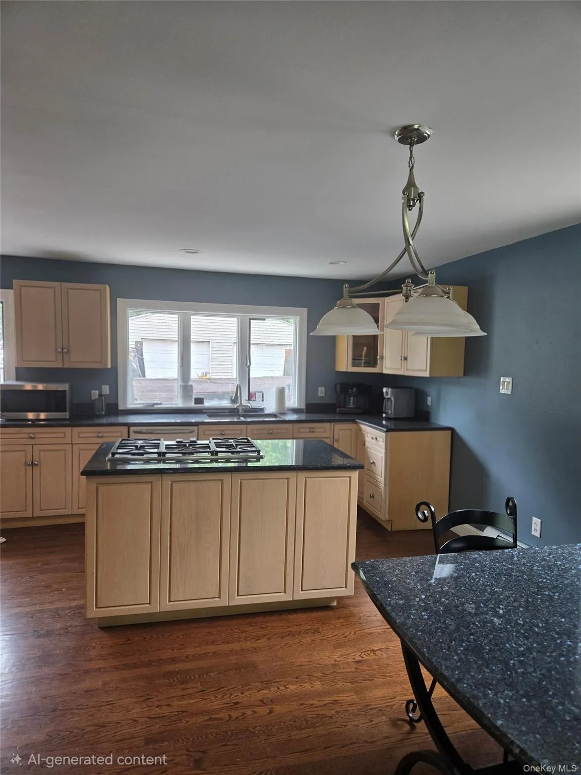 Central kitchen island with a built-in gas cooktop, surrounded by light wood cabinetry and dark countertops Central kitchen island with a built-in gas cooktop, surrounded by light wood cabinetry and dark countertops