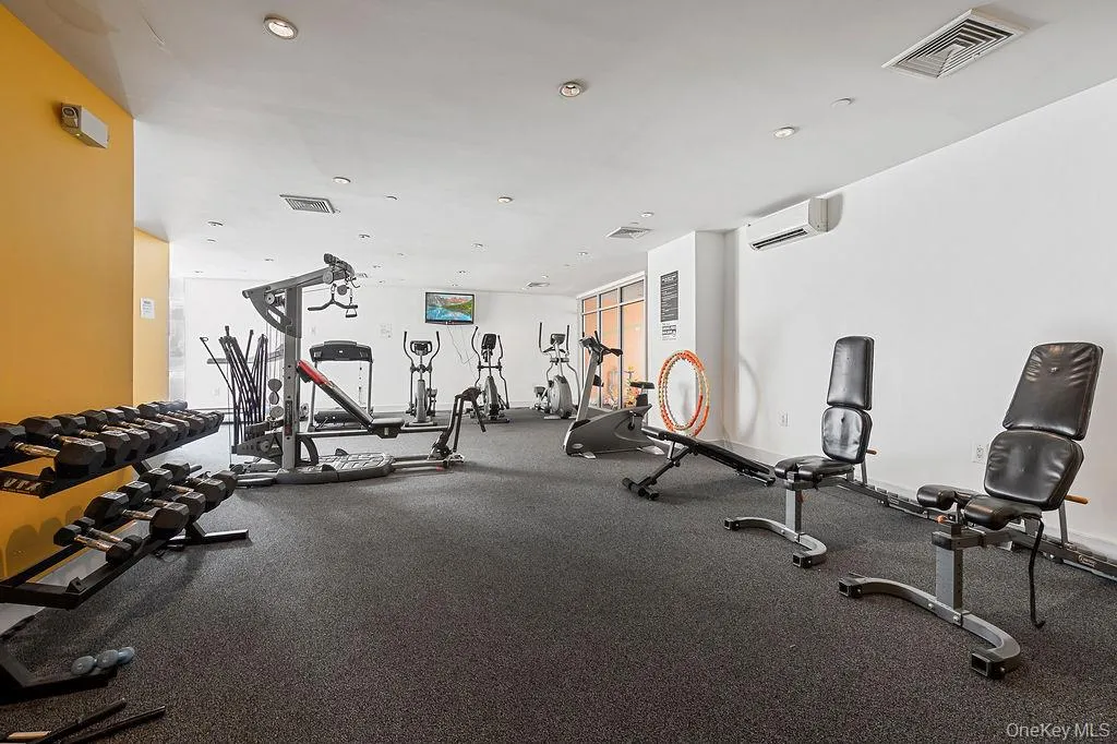 Fitness area featuring a variety of exercise equipment including free weights, weight benches, and cardio machines Fitness area featuring a variety of exercise equipment including free weights, weight benches, and cardio machines