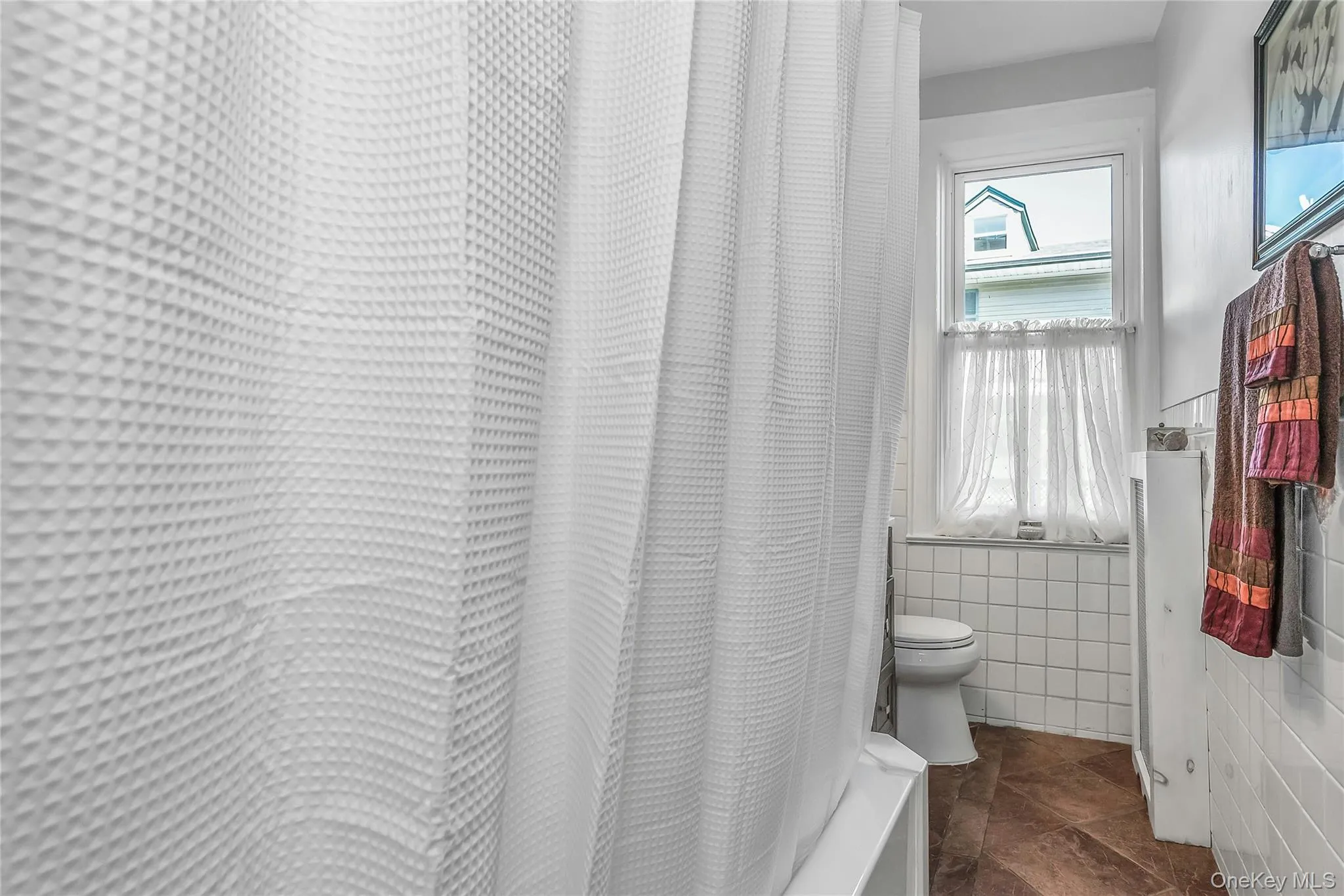 Bathroom decorated with white fixtures, decorative tile and wood vanity Bathroom decorated with white fixtures, decorative tile and wood vanity