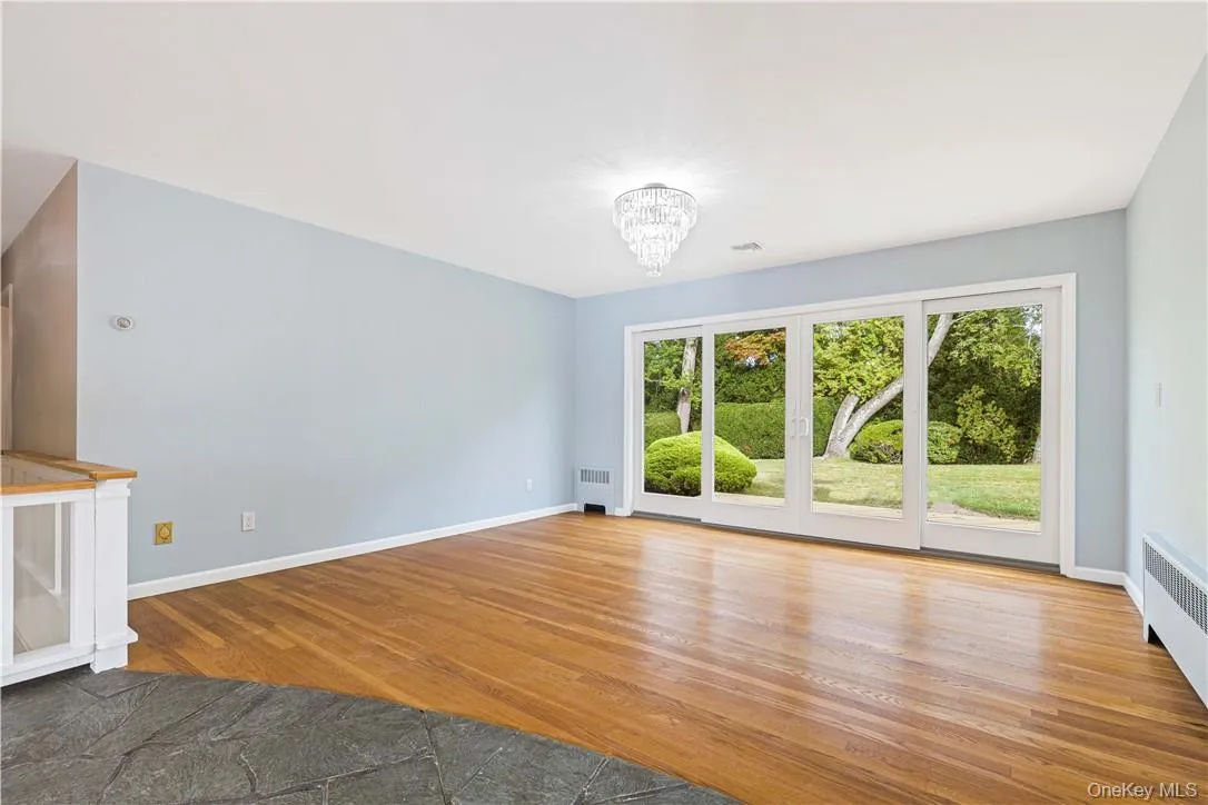 Dining room with an inviting chandelier, double sliding doors to deck and level private yard Dining room with an inviting chandelier, double sliding doors to deck and level private yard