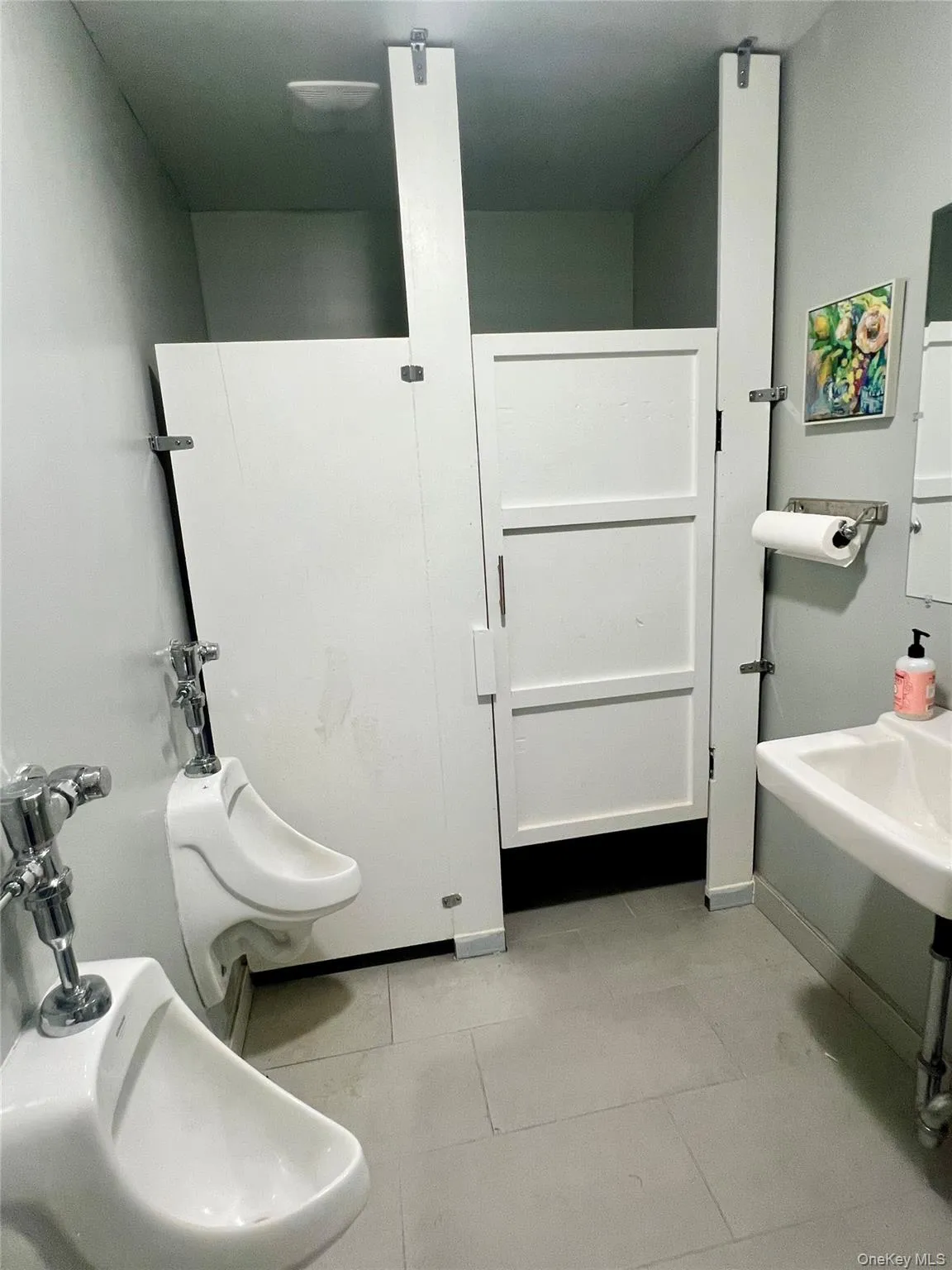 Bathroom with a bidet and light tile patterned flooring Bathroom with a bidet and light tile patterned flooring