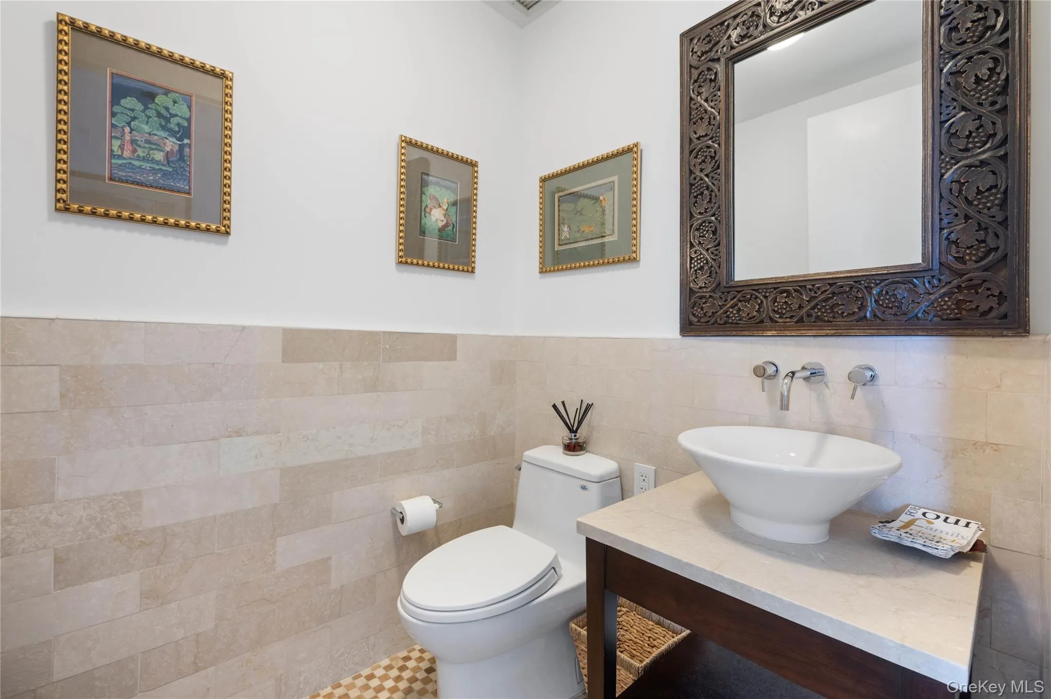 Powder room featuring a vessel sink, wall-mounted faucet, and a decorative carved mirror Powder room featuring a vessel sink, wall-mounted faucet, and a decorative carved mirror