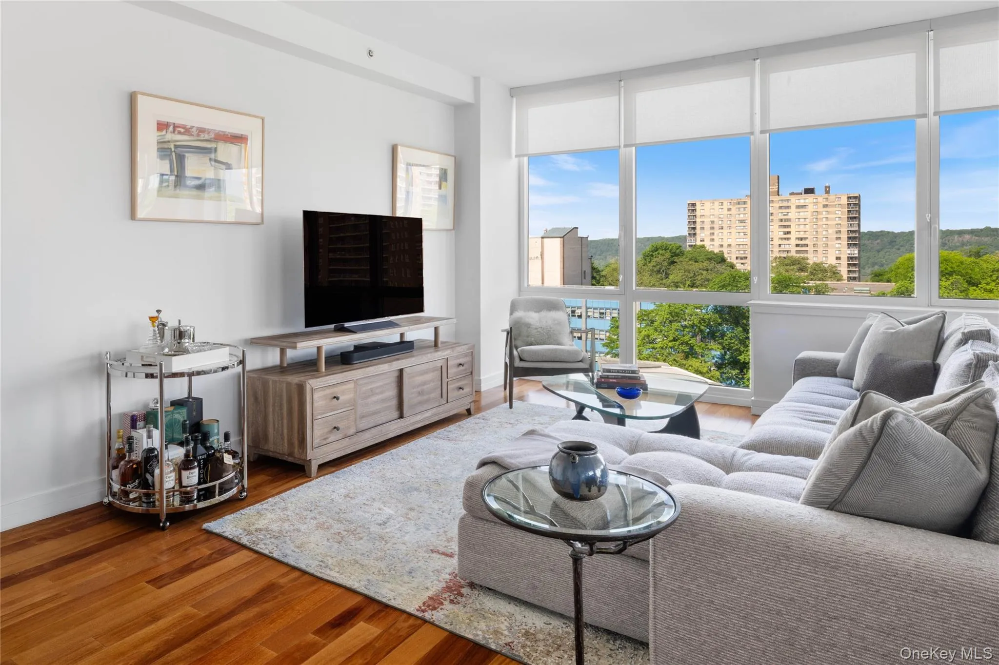 Expansive window wall with roller shades offering scenic distant water and landscape views Expansive window wall with roller shades offering scenic distant water and landscape views