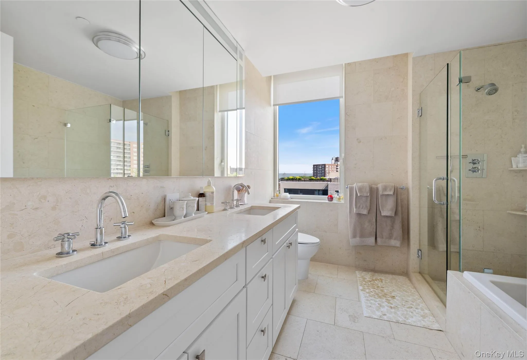 Bathroom featuring a double vanity with integrated sinks, stone-finish countertops, and chrome fixtures Bathroom featuring a double vanity with integrated sinks, stone-finish countertops, and chrome fixtures