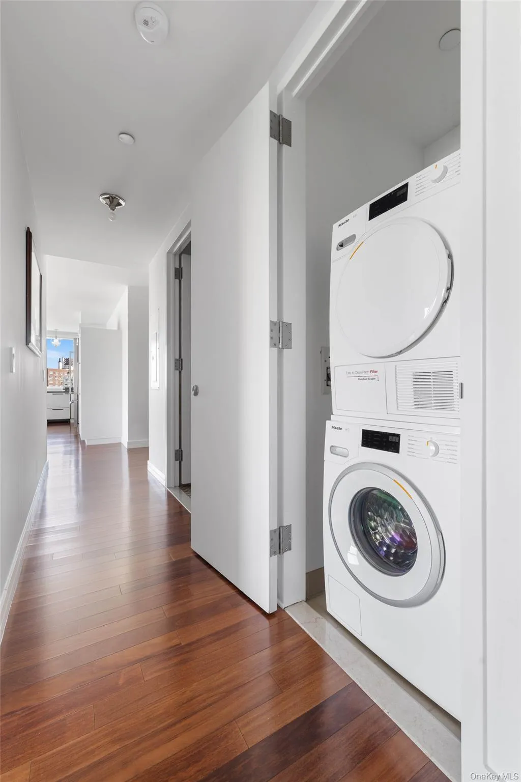 Dedicated laundry area featuring a stacked washer and dryer unit Dedicated laundry area featuring a stacked washer and dryer unit
