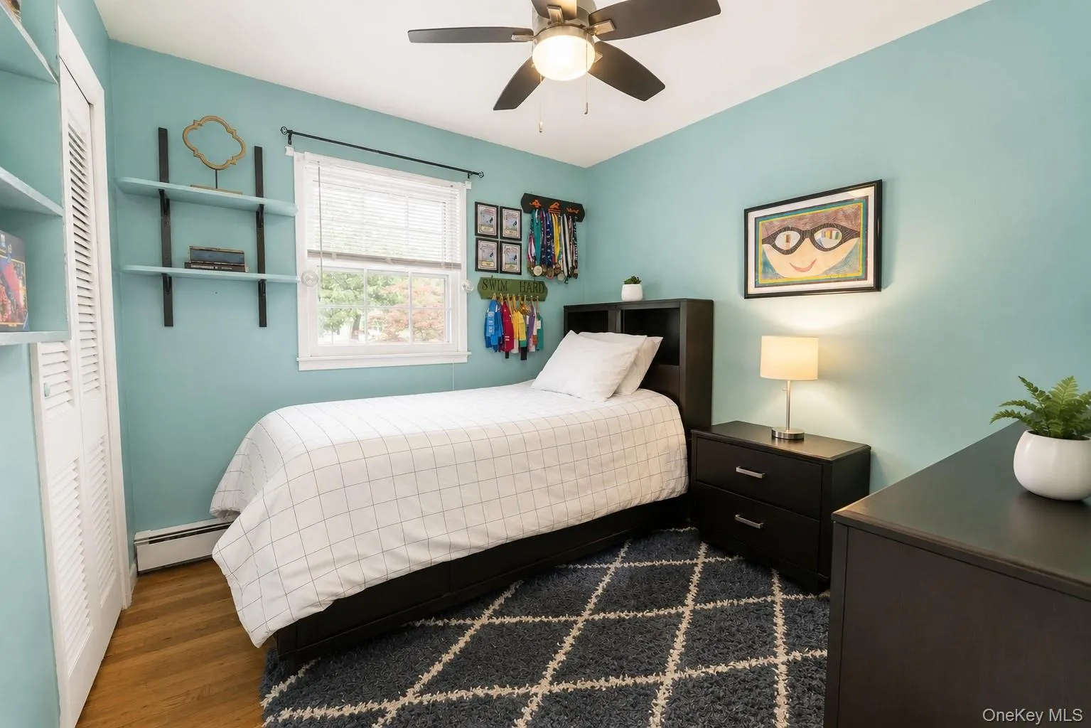 Comfortable third bedroom with hardwood floors, built-in shelving, and a window that brings in beautiful natural light. Comfortable third bedroom with hardwood floors, built-in shelving, and a window that brings in beautiful natural light.