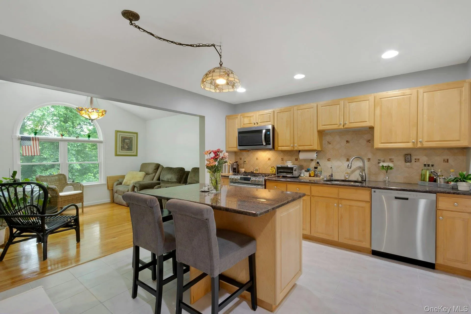 Kitchen to Family Room with hardwood floors and large arched window for plenty of sunlight Kitchen to Family Room with hardwood floors and large arched window for plenty of sunlight