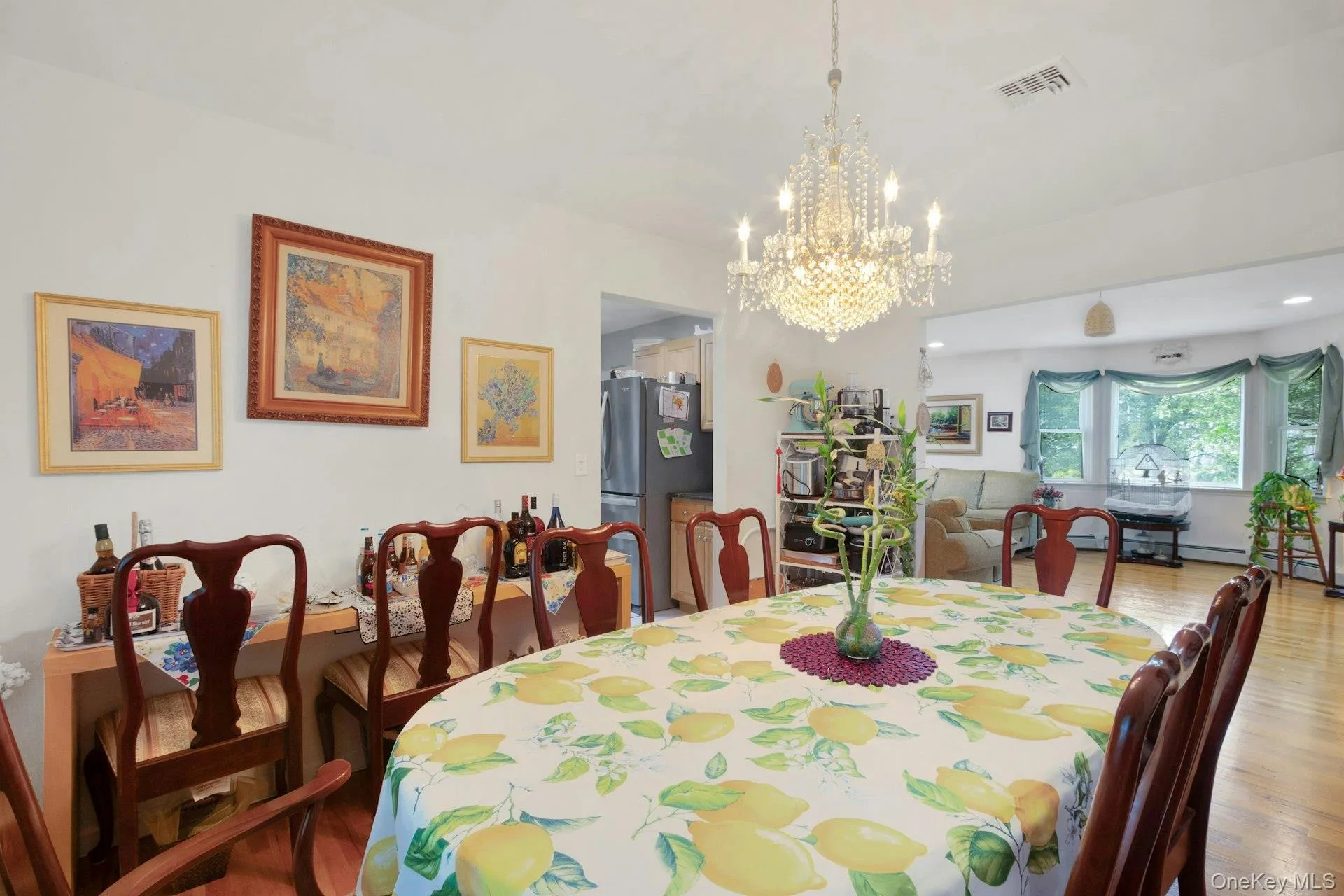 Dining room open to living room with hardwood floors and plenty of sunlight Dining room open to living room with hardwood floors and plenty of sunlight
