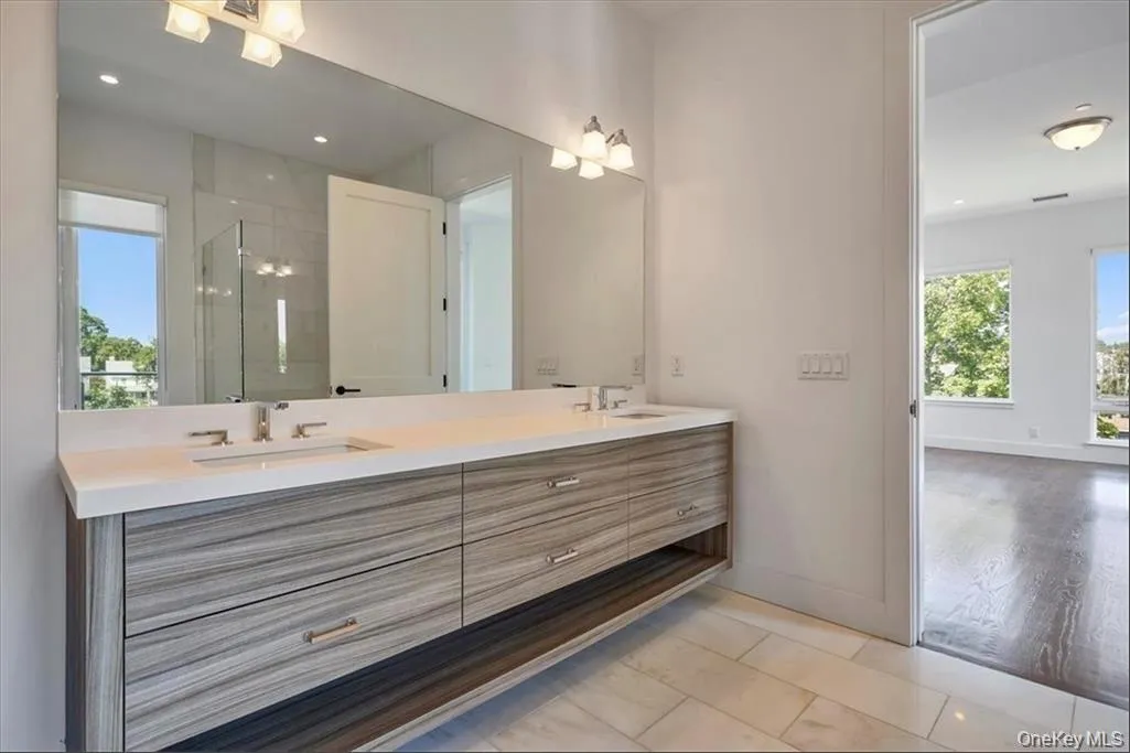 Double vanity with gray wood-finish cabinetry and white countertops Double vanity with gray wood-finish cabinetry and white countertops